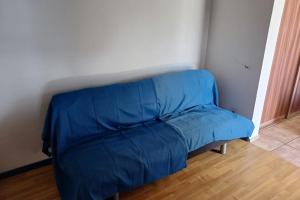 - un canapé bleu dans l'angle de la chambre dans l'établissement Fare Gauguin, à Papeete
