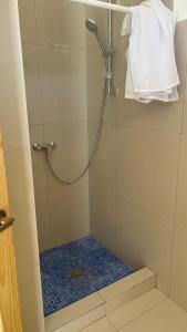 uma casa de banho com um chuveiro e uma porta de vidro em Hotel Bella em Tamarindo