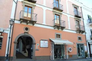 a pink building on a street with a store at Residence Alberghiero Eolie in Lipari