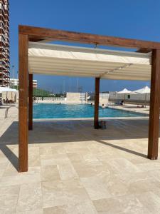 a pavilion with a swimming pool in a city at La casa de bega de mar in Sueca