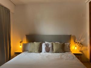 a bedroom with a large white bed with two lamps at La casa de bega de mar in Sueca +8 photos