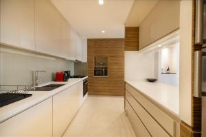 a kitchen with white cabinets and a counter top at Maison Privee - Urban Resort with Golf Course Views, Close to Beach in Dubai