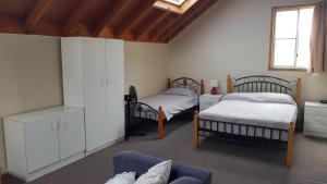 uma sala de estar com duas camas e um sofá em Billungar Unit 2 at Hat Head - Unit 2 of 1 Creek St- No Sheets or Towels Provided em Hat Head