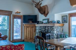 una sala da pranzo con camino e tavolo con testa di cervo sopra di esso di Greyhawk Condo 10 - Great Location Close to Bald Mt Hiking and Skiing a Ketchum