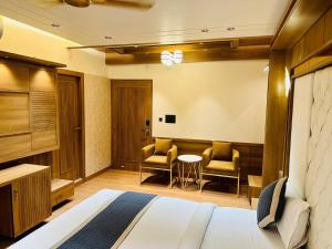 a hotel room with a bed and two chairs at Hotel Safari in Jaipur