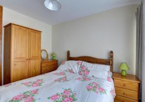 a bedroom with a bed with pink flowers on it at Barn 1 in Berriew