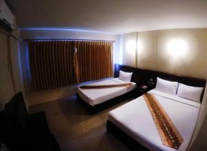 a hotel room with two beds and a window at Chiangkhong Green Inn Resident in Chiang Khong