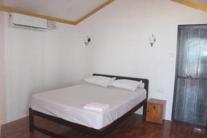 a bedroom with a bed with white sheets and a window at Nikhil's Beach Cottages in Canacona