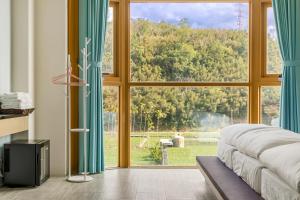 a bedroom with a large window with a view at Quan Ming B&B in Dahu