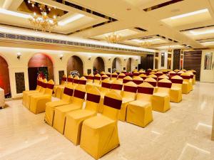 a large room with yellow chairs and tables at Hotel Safari in Jaipur