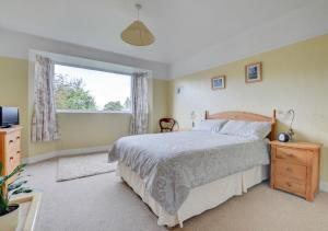 a bedroom with a bed and a window at Norbury in Penmaen-mawr