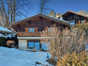 une maison en rondins avec une terrasse dans la neige dans l'établissement Mirador Lodge - Crans Montana - Swiss Alps, à Crans-Montana