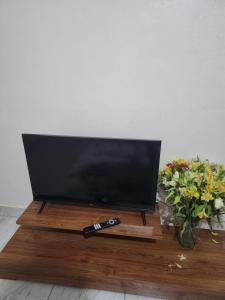 a television on a wooden stand with a remote control at Muthiga Springs Apartment in Kikuyu