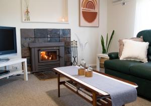a living room with a fireplace and a green couch at Entire house in Minnipa - 3 bedroom, sleeps 5 in Minnipa