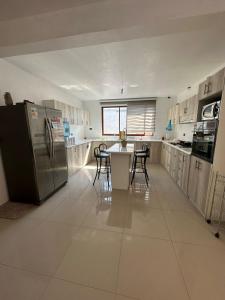 a large kitchen with a table and a refrigerator at Casa cómoda, grande y agradable. in Arica