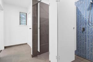 een badkamer met een douche met blauwe tegels bij Thomson Rest in Belmont