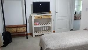 Dormitorio con cama y tocador con TV en Los Abuelos en Duggan