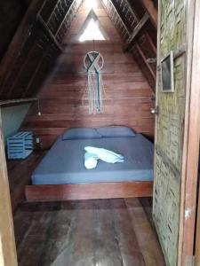 sypialnia z niebieskim łóżkiem w drewnianym domu w obiekcie CRUISER'S BEACH RESORT w mieście San Agustin