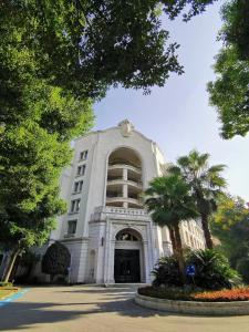 a white building with a palm tree in front of it at Shanghai Fenyang Garden Boutique Hotel in Shanghai