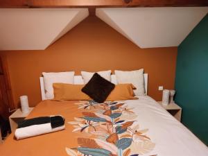 ein Schlafzimmer mit einem großen Bett mit orangefarbenen Wänden in der Unterkunft Location Chambres Le Panorama - Aéroport Genève - Pays de Gex in Chevry