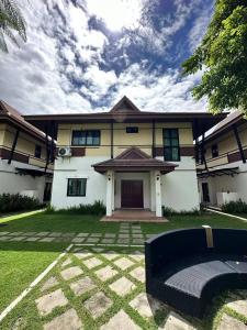 uma grande casa branca com um relvado em frente em The deer resort em Chiang Mai