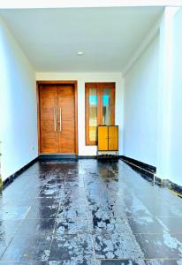 an empty room with wooden doors and a tile floor at Villa 005 in Kirillapone