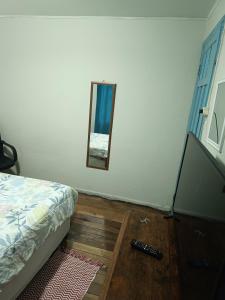 1 dormitorio con cama y espejo en la pared en Habitación grande céntrica, en La Serena