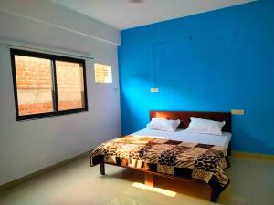 グワーリヤルにあるOYO Hotel Mount Viewの青い壁のベッドルーム1室、ベッド1台が備わります。