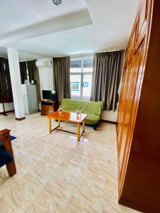 a living room with a green couch and a coffee table at BT hotel Kata Beach in Kata Beach