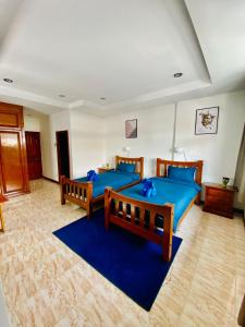 una camera con 2 letti e un tappeto blu di BT hotel Kata Beach a Kata Beach