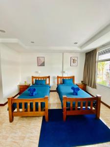 two beds in a room with blue pillows at BT hotel Kata Beach in Kata Beach