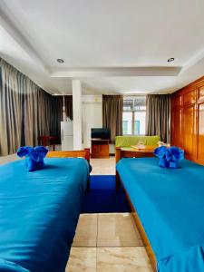two beds in a room with blue sheets at BT hotel Kata Beach in Kata Beach