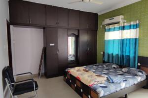 een slaapkamer met een bed en een stoel erin bij Luxurious 3 bhk apartment with swimming pool in Bangalore