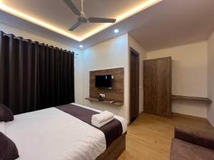 um quarto com uma cama e uma televisão de ecrã plano em OYO The Royal Empire em Agra