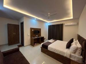 a bedroom with a bed and a desk and a television at OYO The Royal Empire in Agra