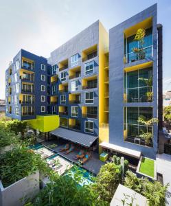 een appartementencomplex met een zwembad ervoor bij LiT BANGKOK Residence in Bangkok