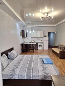 a large bed in a living room with a kitchen at ЖК Сункар in Almaty