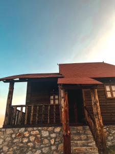 Cabaña de madera con porche y techo en Cabañas y Venados Omega Ranch en Pénjamo