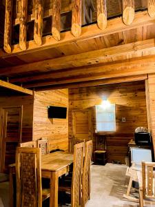 comedor de madera con mesa y sillas en Cabañas y Venados Omega Ranch en Pénjamo