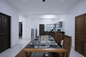 een eetkamer met een tafel en stoelen in een keuken bij INDIGO PALMS in Trivandrum