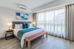 1 dormitorio con cama grande y ventana grande en Stay Regency Menlyn, en Pretoria