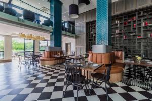 a restaurant with tables and chairs and a checkered floor at Stay Regency Menlyn in Pretoria