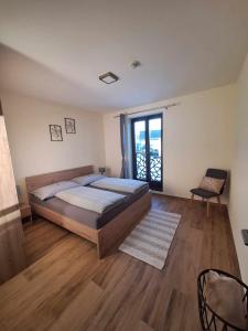 a bedroom with a large bed and a window at Apartmány Zaky in Vrbov