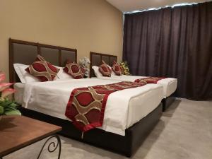 1 dormitorio con 2 camas y almohadas blancas y rojas en KB HOTEL, en Kepala Batas