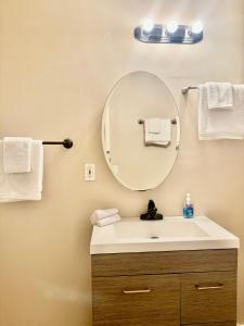 ein Bad mit einem Waschbecken, einem Spiegel und Handtüchern in der Unterkunft New remol modern tranquil house near SFO in San Mateo