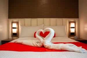 two swans making a heart on a bed at Hayat Sky Towers Service Apartment in Cebu City