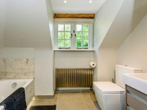 a bathroom with a toilet and a window at 5 Bed in Rye 82395 in Peasmarsh