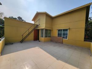 a yellow house with a patio in front of it at Aaira manjil1 in Dhaka