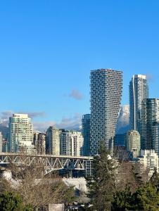 a view of a city with a bridge and buildings at Charming Heritage Home with Mountain and City Views in Vancouver