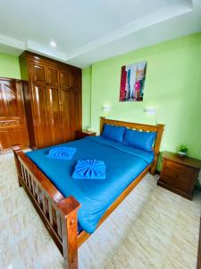 BT hotel Kata Beach في شاطئ كاتا: غرفة نوم مع سرير أزرق كبير مع وسائد زرقاء